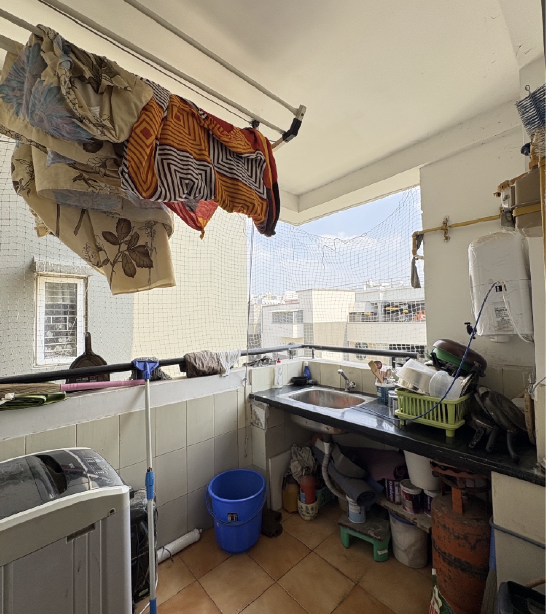 Raw listing photo of a cluttered utility balcony